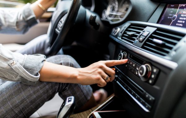 car-dashboard-radio-closeup-woman-sets-up-radio-while-driving-car